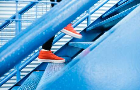 Red sneakers running up a staircase
